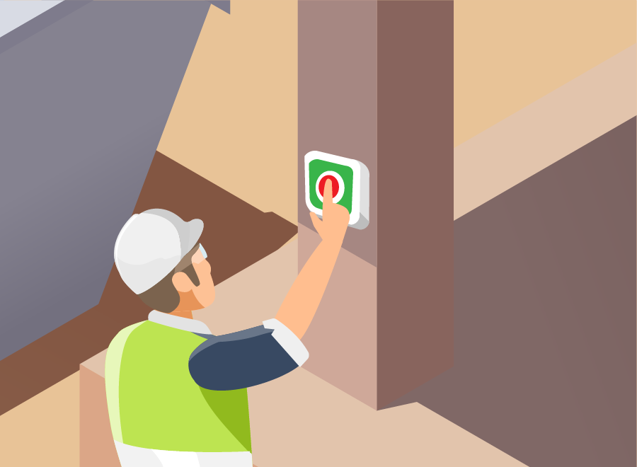 Ein Bauarbeiter drückt auf einen Knopf, der an einer Säule angebracht ist.