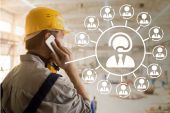 Arbeiter mit gelbem Schutzhelm telefoniert, daneben Schema von mehreren Konferenzteilnehmern