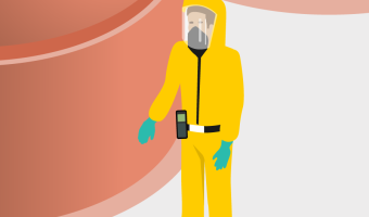 Mitarbeiter in gelbem Schutzanzug steht vor Silos