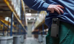 Mitarbeiter in einer Lagerhalle mit einem tragbaren mobilen Telefon in einer Gürteltasche