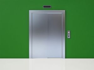 Closed elevator door in a green-painted wall