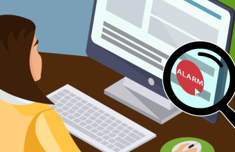 Mitarbeiterin sitzt vor Bildschirm mit kleinem Alarmknopf