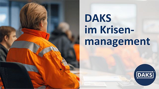 Text panel on the right ‘DAKS in crisis management’ in front of a group of people in orange overalls in a briefing situation