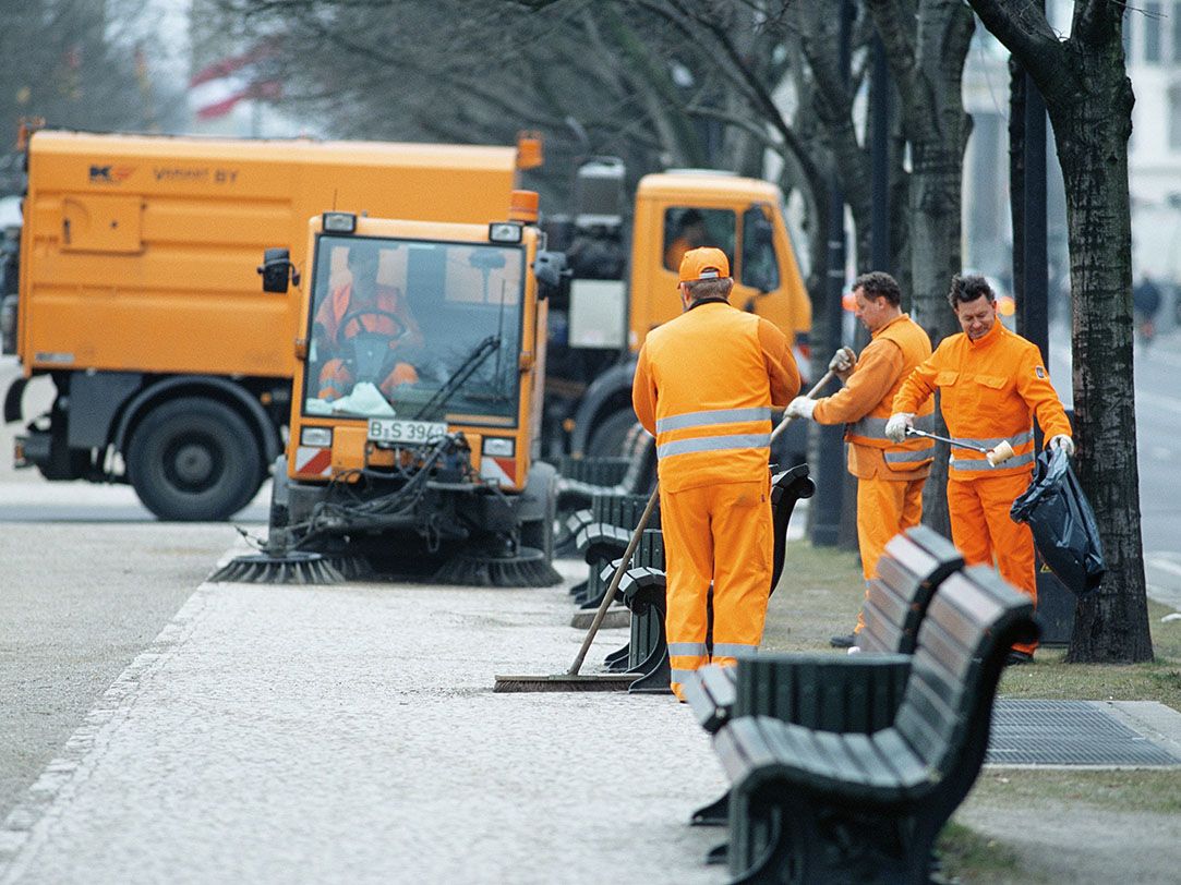 Photo of orange cleaning vehicles and orange-clad employees of the Berliner Stadtreinigung