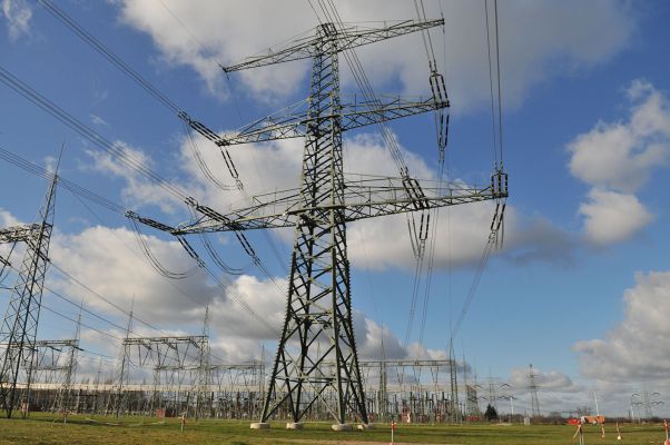 Overhead power line with substation in the background